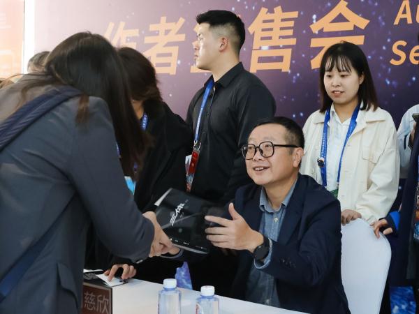 　10月20日，刘慈欣（前右）在现场为科幻迷签名。新华社记者 沈伯韩 摄